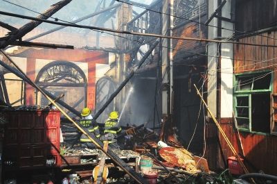 “杏花天”的第三進(jìn)房屋被燒毀,消防人員正在撲救