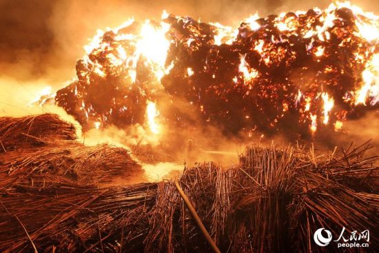 圖為消防官兵正在淋濕附近的堆垛，防止火勢蔓延。陸沉/CFP