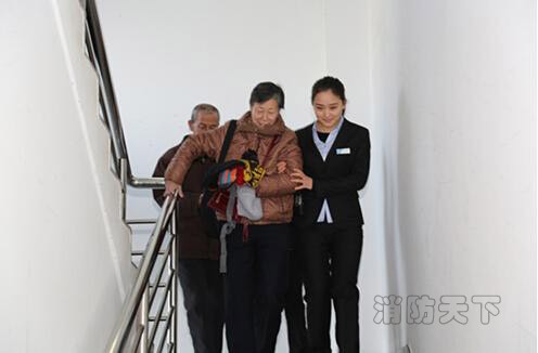 工作人員扶著老年參觀人員從逃生通道離開。